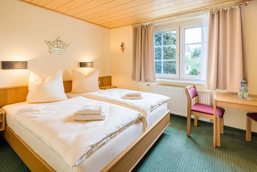 Guest room with light wood and green carpeting